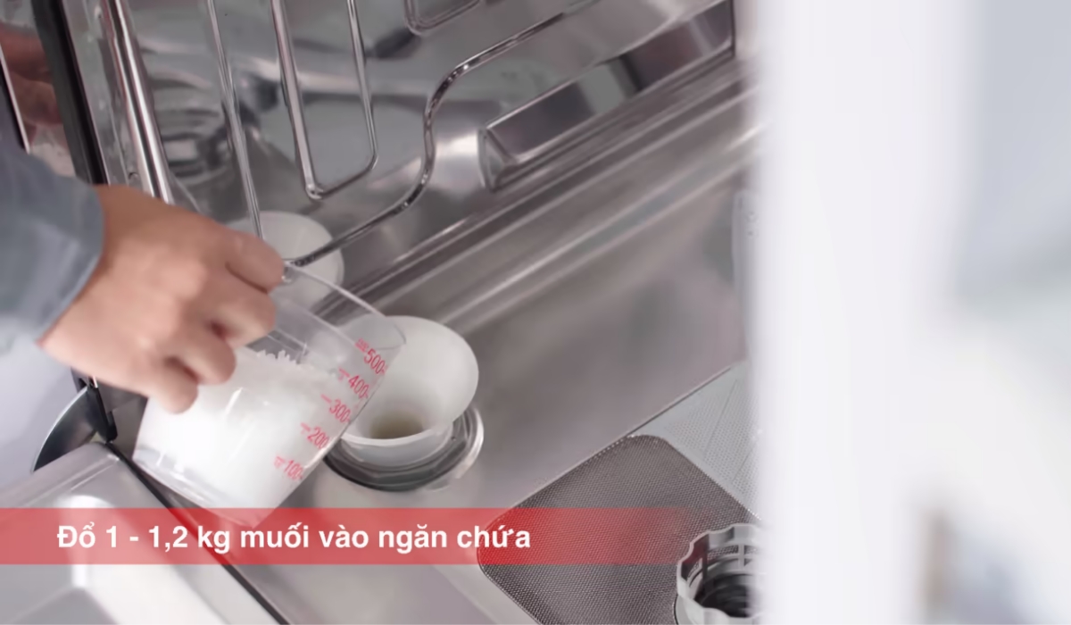 Đặt đáy phễu vào miệng ngăn chứa và đổ khoảng 1kg muối vào